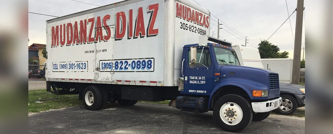Mudanzas Diaz box truck with blue cab parked on a residential street